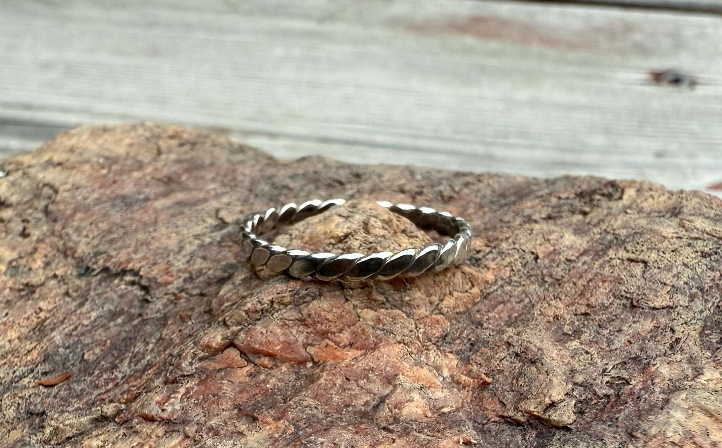 Silver ring on a textured stone surface
