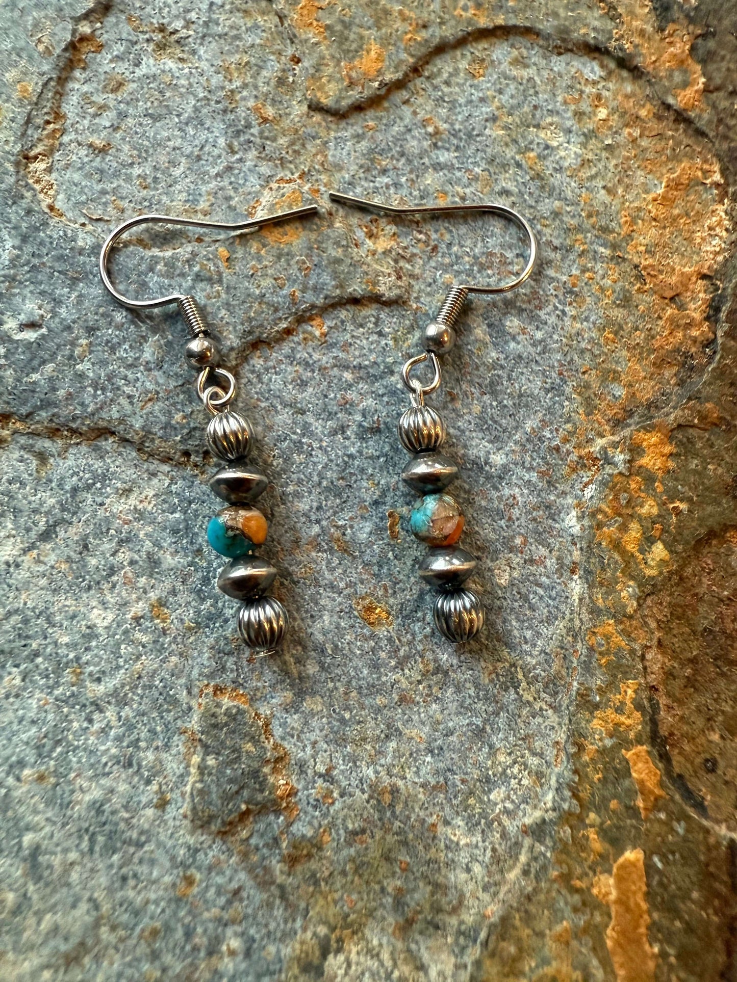 Sterling Silver Pearls & Spiny Oyster Earrings showcasing vibrant turquoise and orange beads on a textured stone background.
