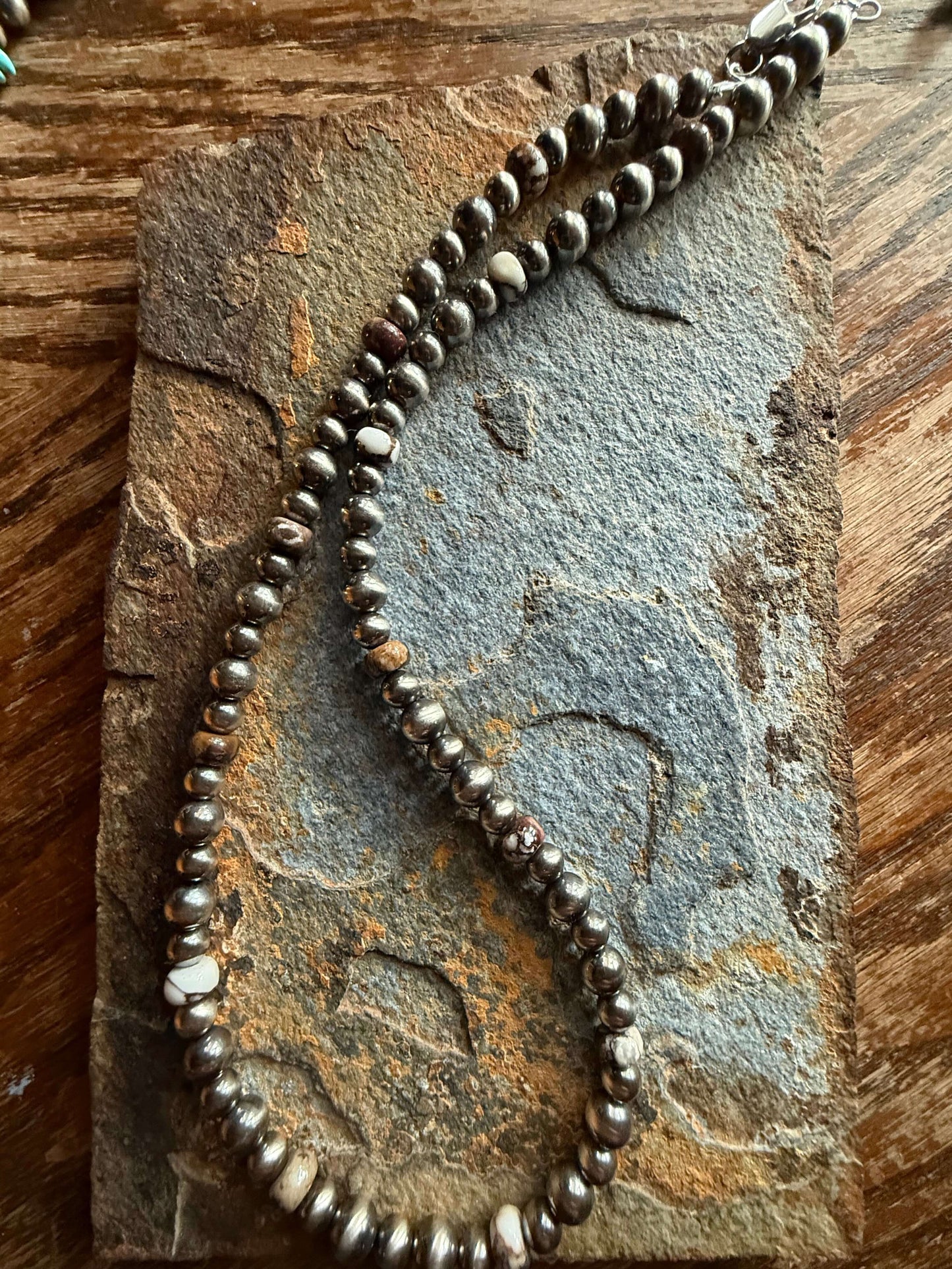 Sterling Silver Pearls and Wild Horse Magnesite Necklace displayed on a textured stone surface.