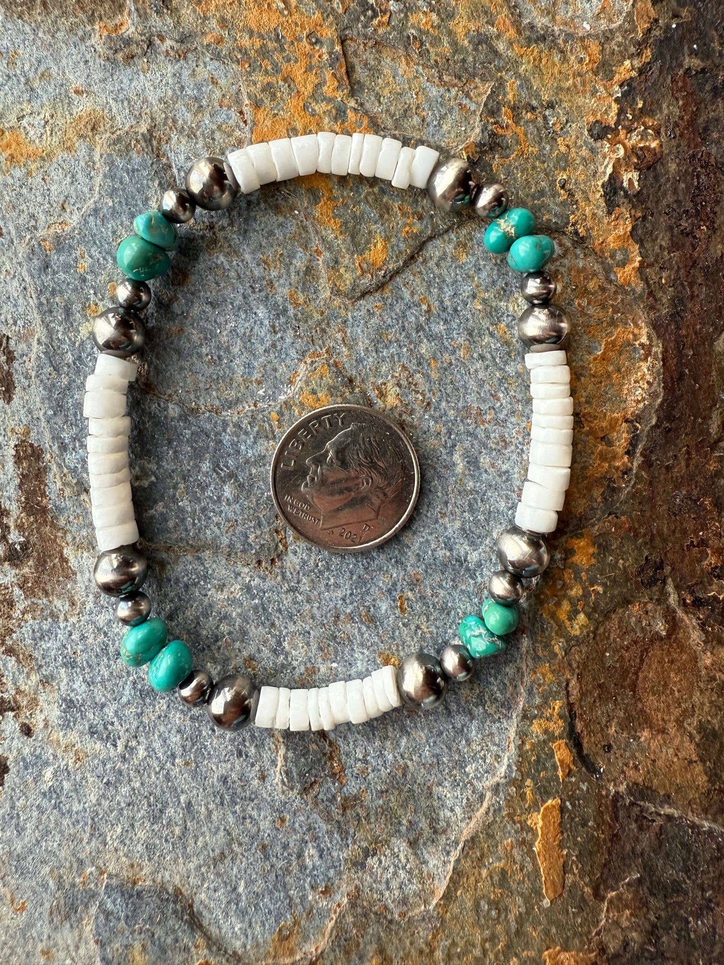 Lone Mountain Turquoise Pearl Bracelet displayed with a quarter for size comparison on a textured surface.