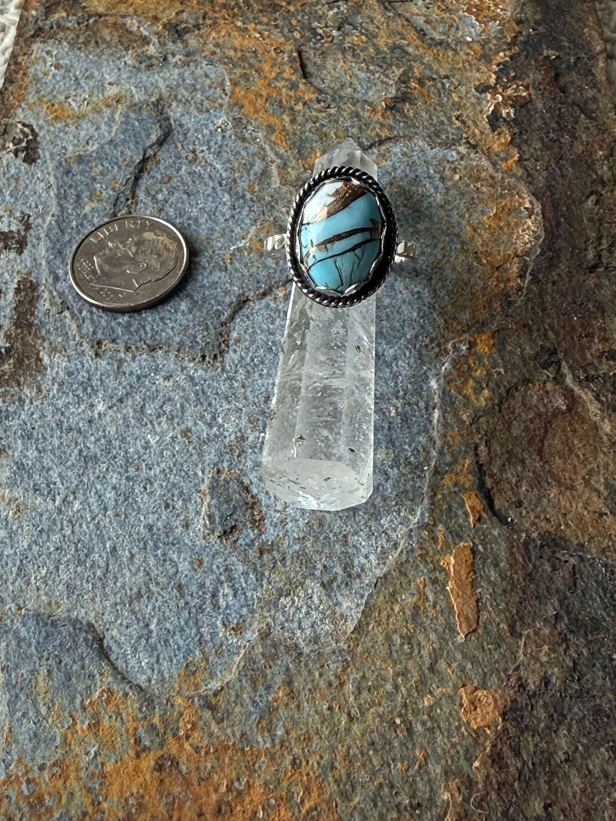 Cotton Candy Dahlia Sterling Silver Ring on a stone surface with a coin for size reference.