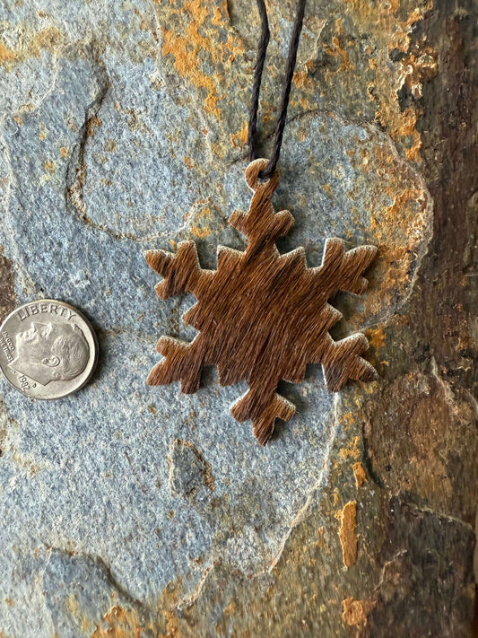 Hair on cowhide mini snowflake ornamentsHair on cowhide mini snowflake ornaments hanging next to a coin for size reference.