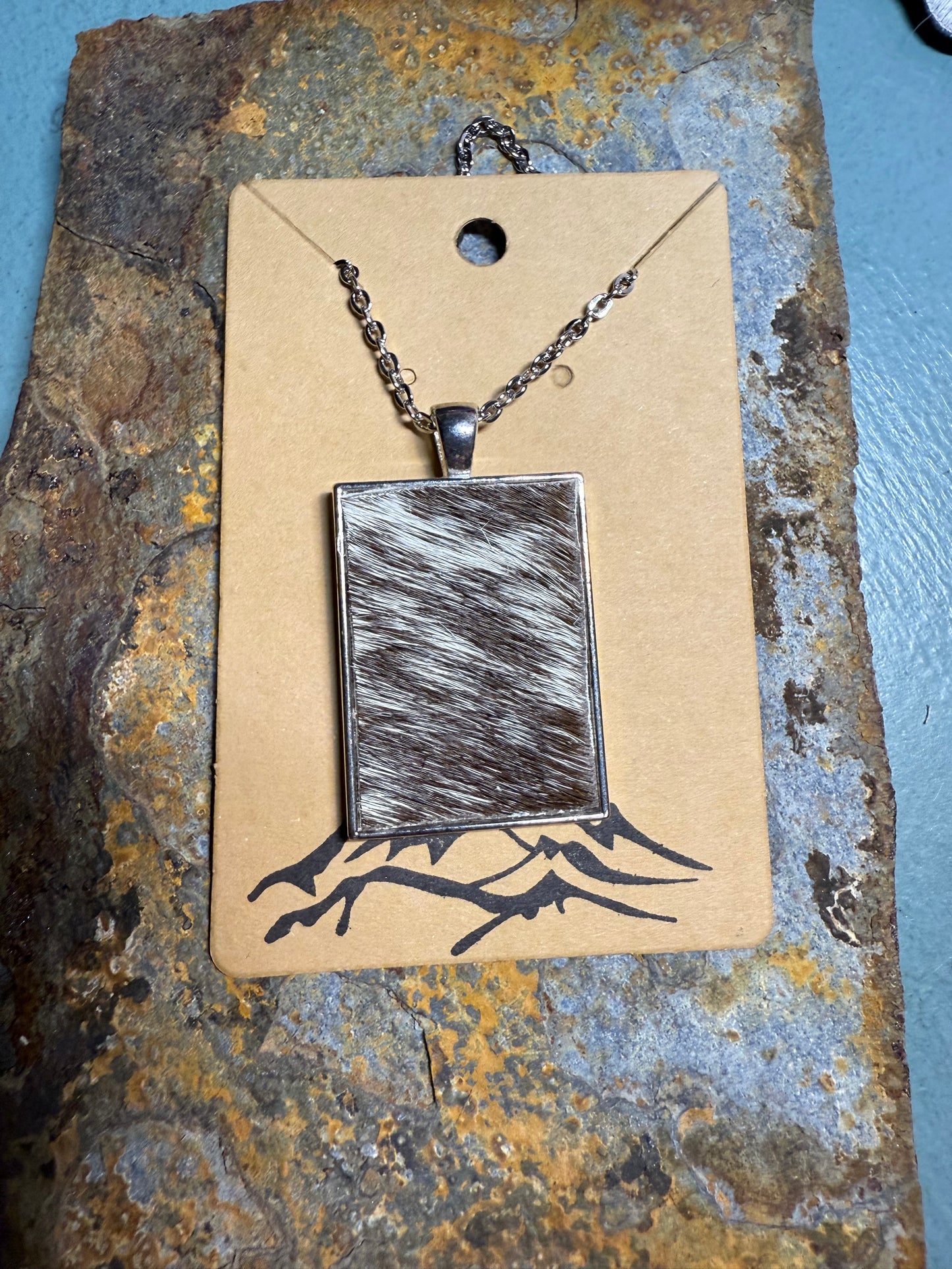 Brown/white hair-on cowhide rectangle shaped pendant with chain