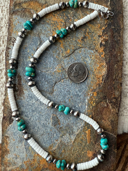 Necklace with Lone mountain turquoise and white shell and silver pearl beads on a textured stone surface