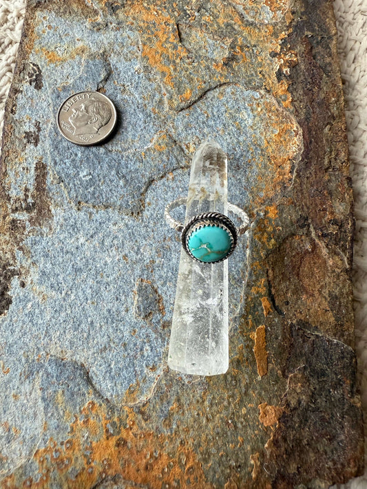 Focus Keyword Fox Turquoise Ring displayed on a stone surface next to a quarter for size reference.