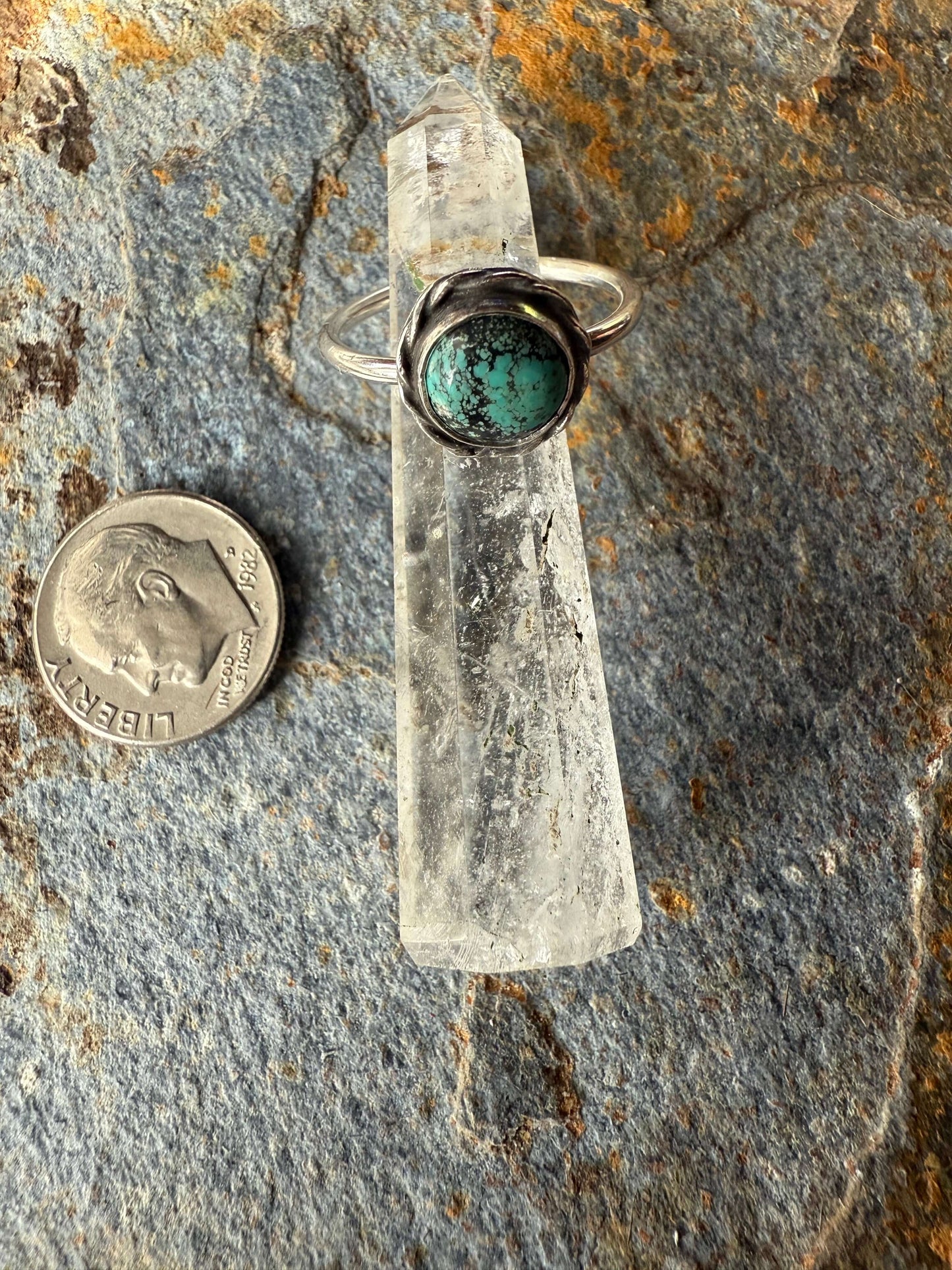 Blue Moon Turquoise Sterling Silver Ring displayed next to a coin for size reference on a textured stone background.