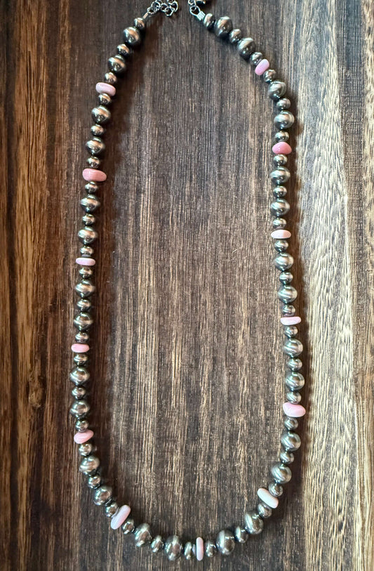 Pink Conch Shell Chip Sterling Silver Pearls Necklace 18 inch on a wooden background.