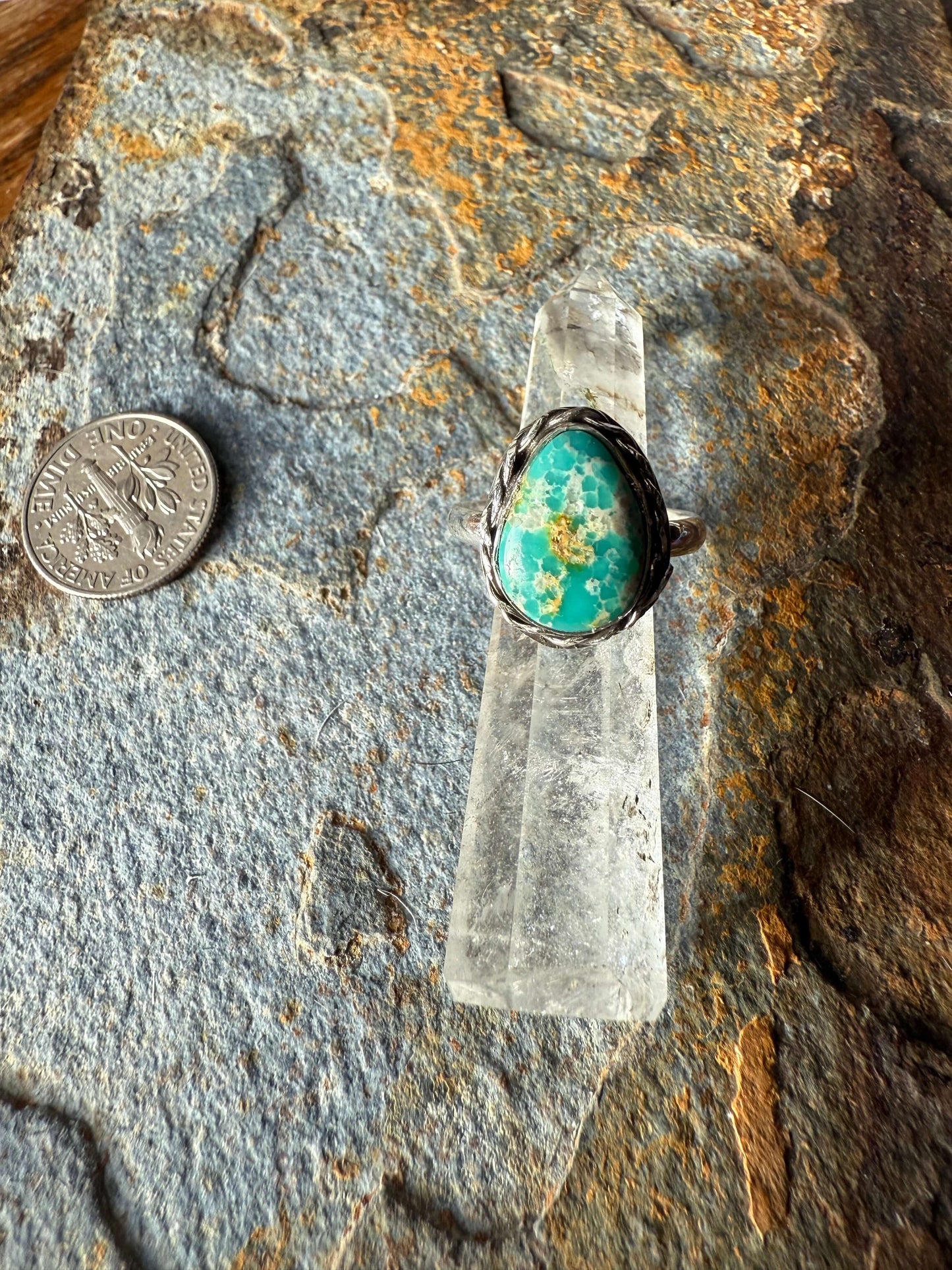 White Water Turquoise Sterling Silver Ring White Water Turquoise Sterling Silver Ring displayed on natural stone with a coin for scale.