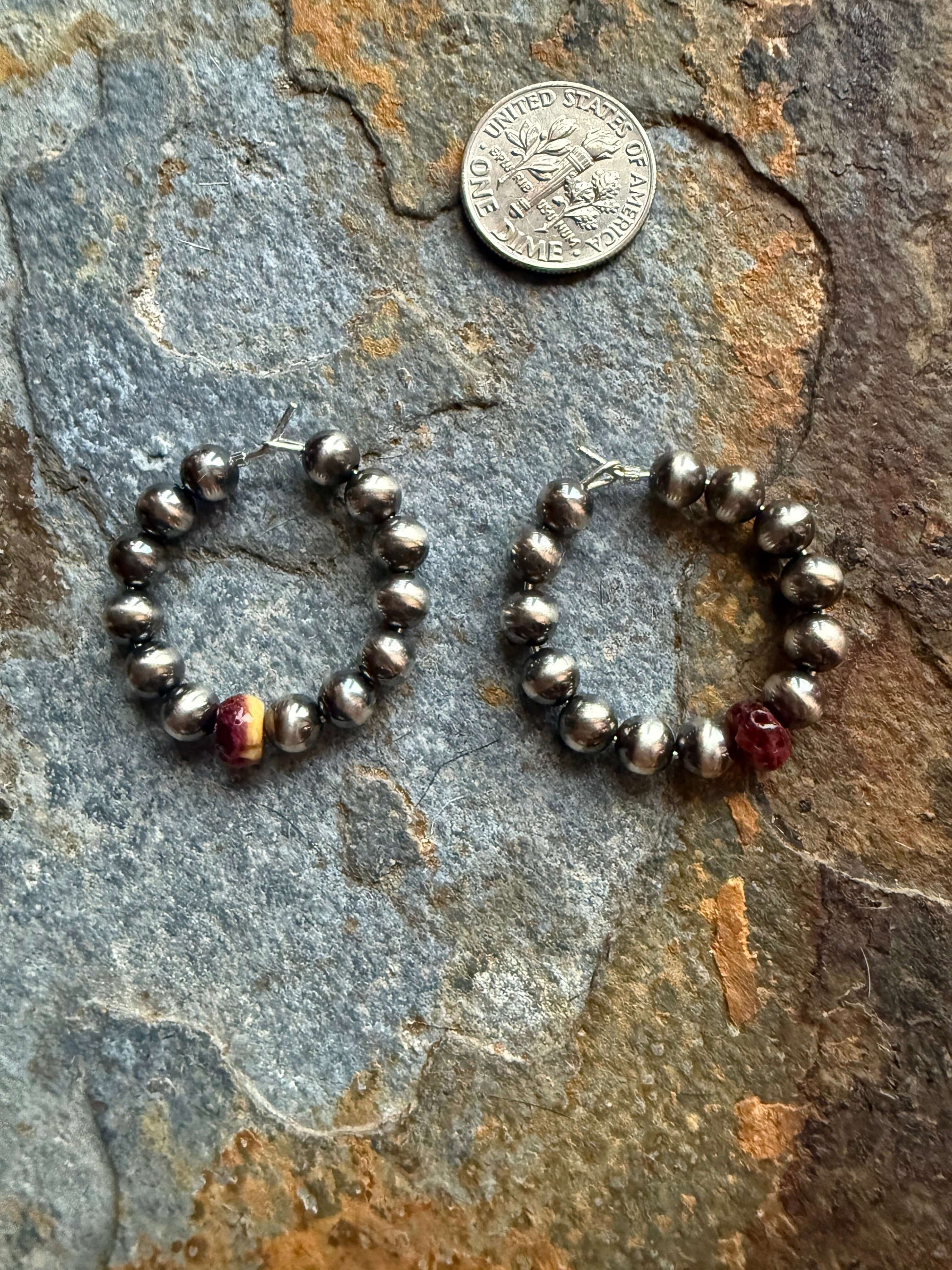 Sterling silver spiny oyster hoop earrings featuring vibrant beads and elegant design beside a coin for size reference.