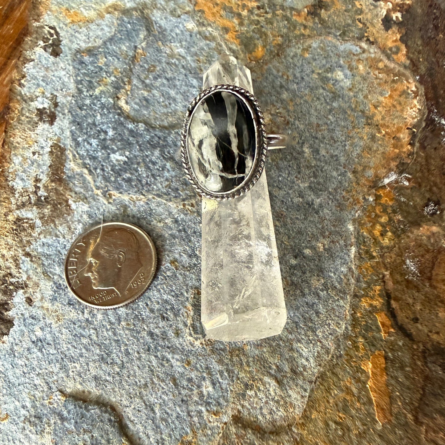  Black and white stone silver ring on a stone background