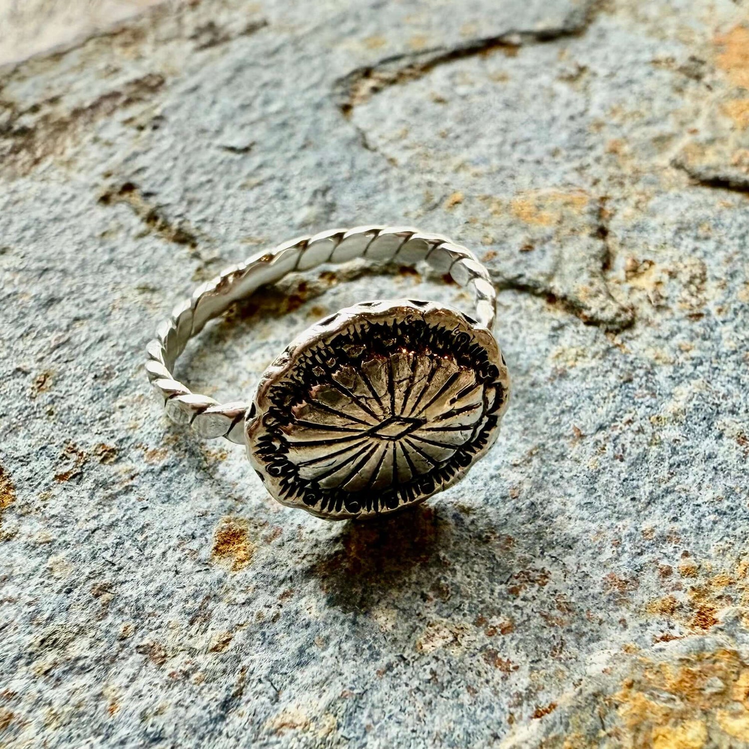 Close-up of a silver concho ring with intricate Western detailing, inspired by Southwestern jewelry. Adjustable fit, perfect for cowgirl and rodeo fashion